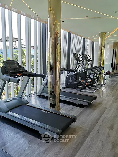 Luxurious gym with modern treadmills and floor-to-ceiling windows in a high-end residential building.