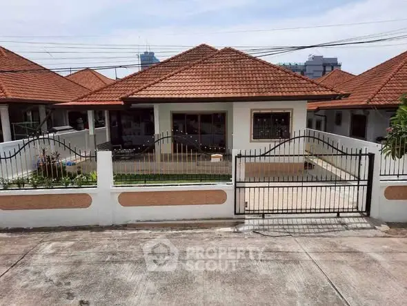 Charming single-story home with red-tiled roof and gated entrance in a serene neighborhood.