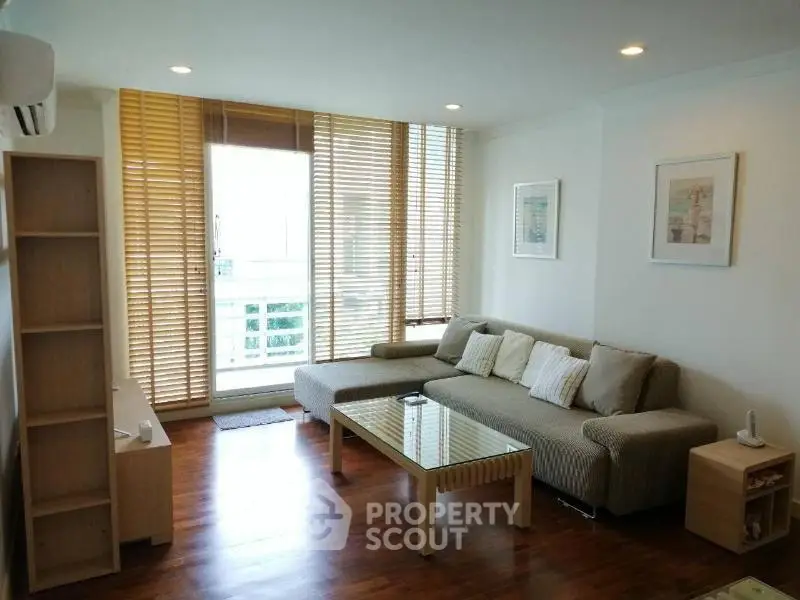 Modern living room with cozy sofa and wooden blinds in a bright apartment.