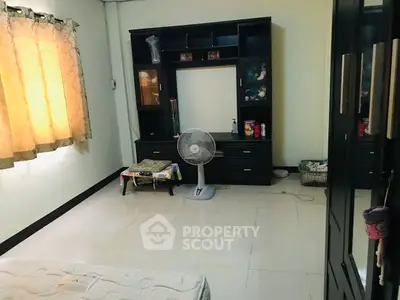 Spacious bedroom with natural light and modern furniture, perfect for comfortable living.