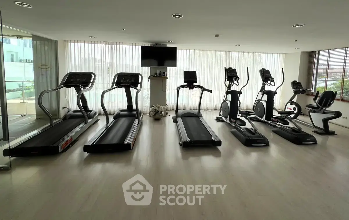 Modern gym with state-of-the-art equipment and large windows for natural light.