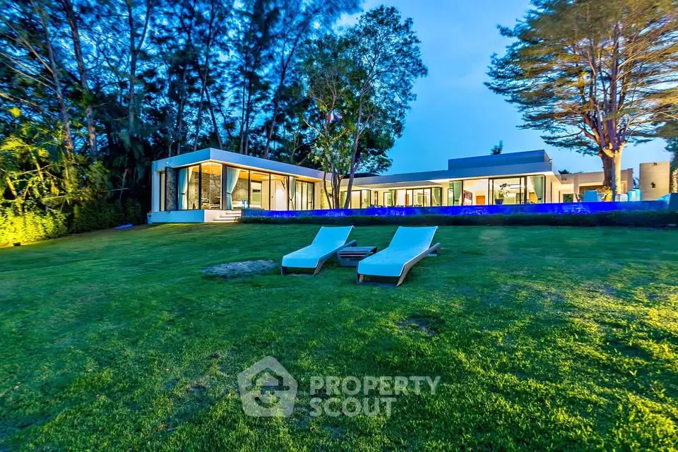Luxurious modern villa with expansive lawn and stunning architecture at dusk.