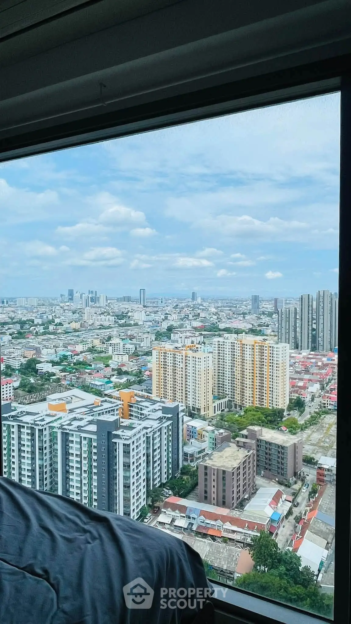 Stunning cityscape view from a high-rise apartment window, showcasing urban skyline and vibrant city life.