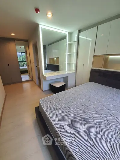 Modern bedroom with built-in wardrobe and stylish vanity in a contemporary apartment.