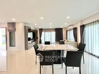 Spacious modern living room with elegant dining area and large windows for natural light.