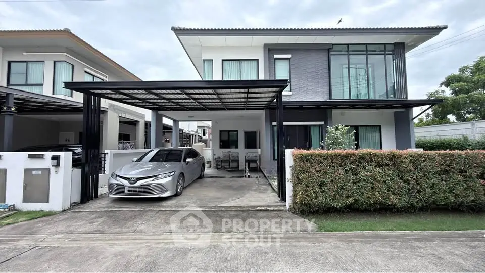 Modern two-story house with carport and sleek design in a suburban neighborhood.