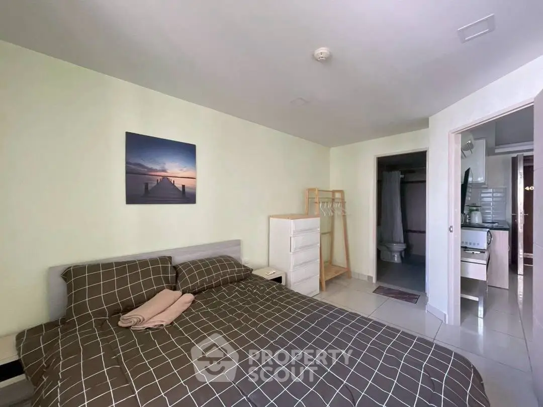 Cozy bedroom with modern decor and ensuite bathroom in a stylish apartment.