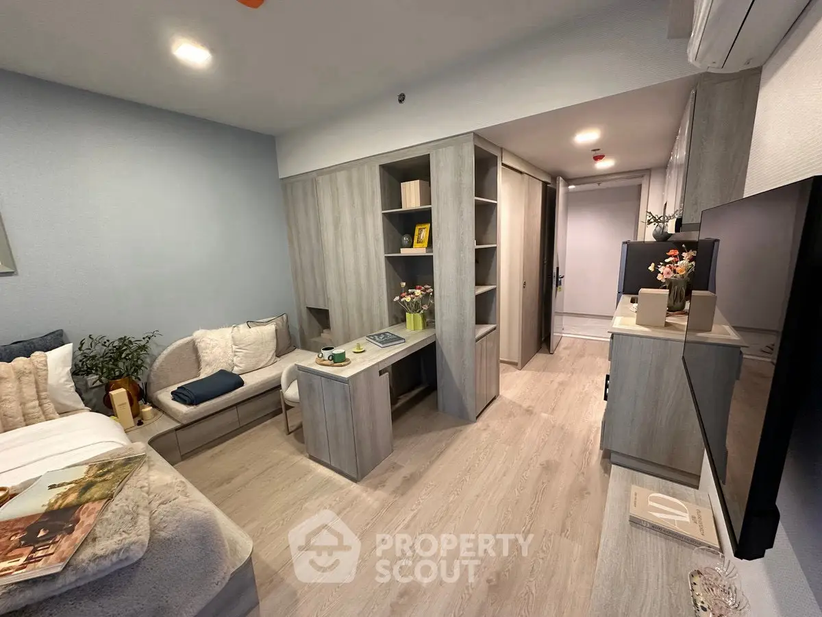 Modern studio apartment with stylish decor and efficient use of space, featuring cozy seating and smart storage solutions.