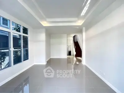 Spacious modern living room with large windows and glossy tiled floors