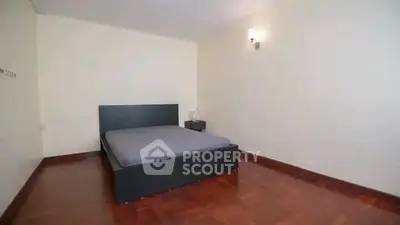 Spacious bedroom with wooden flooring and modern bed frame