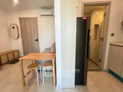 Modern apartment interior with compact dining area and sleek kitchen design.