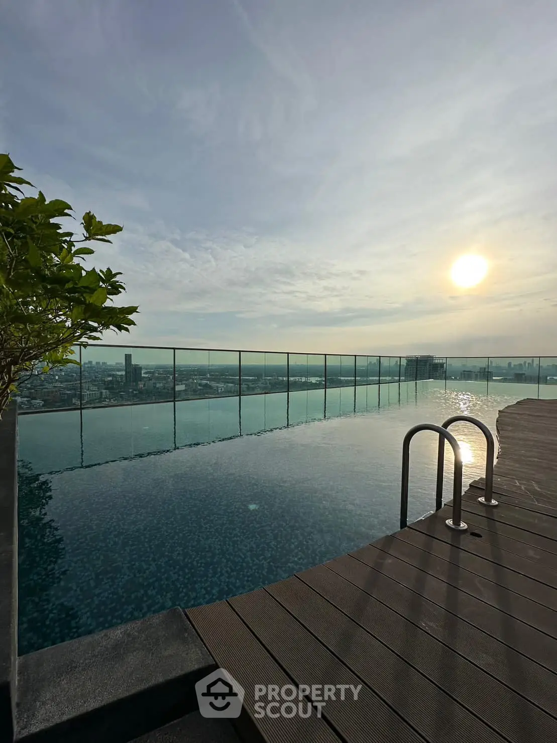 Stunning rooftop infinity pool with panoramic city views at sunset.
