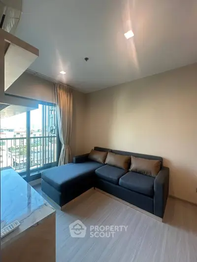 Modern living room with stylish sofa and balcony view in a contemporary apartment.