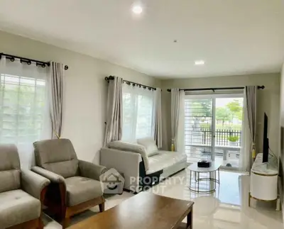 Spacious living room with modern furniture and large windows offering natural light.