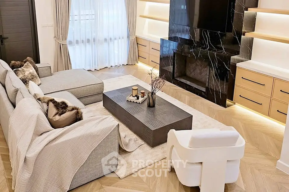 Luxurious living room with elegant decor, featuring a modern fireplace and stylish furniture.