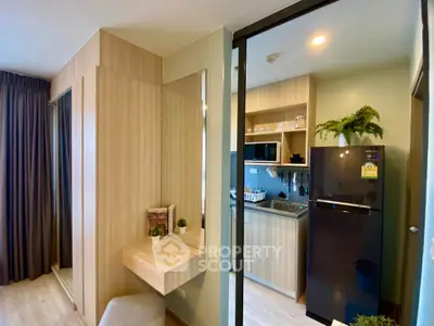 Modern compact kitchen with sleek appliances and cozy dining area in stylish apartment.