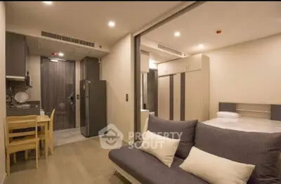 Modern studio apartment with open layout, featuring cozy living area and compact kitchen.