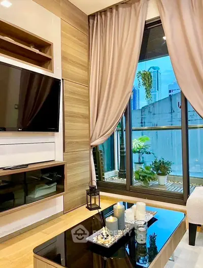 Modern living room with large window and city view, featuring stylish decor and entertainment center.
