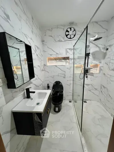 Modern bathroom with sleek black fixtures and marble tiles