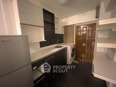 Compact kitchen with modern appliances and washing machine in cozy apartment