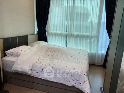 Cozy bedroom with large window and elegant curtains, featuring a comfortable bed with stylish bedding.