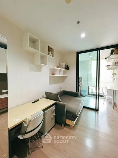 Modern apartment interior with cozy study area and sliding glass doors.