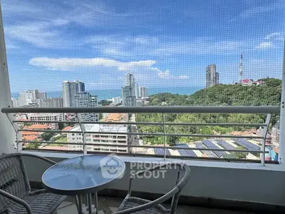 Stunning high-rise balcony view with ocean and cityscape, perfect for relaxation and enjoying the skyline.