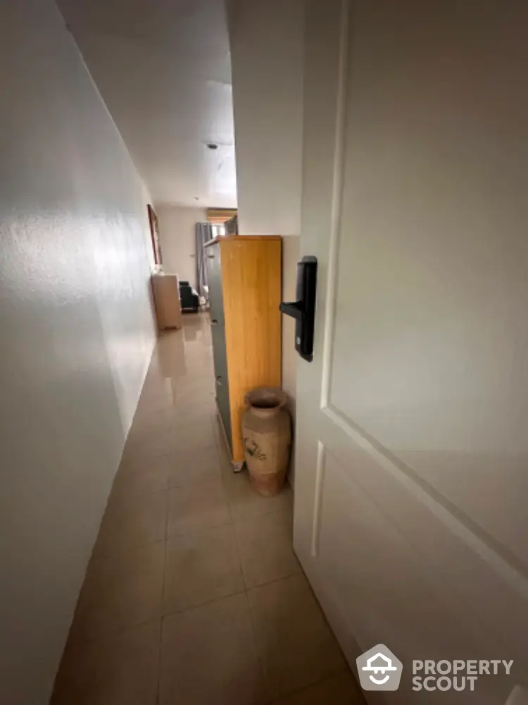 Narrow hallway with tiled floor and minimal decor in modern home