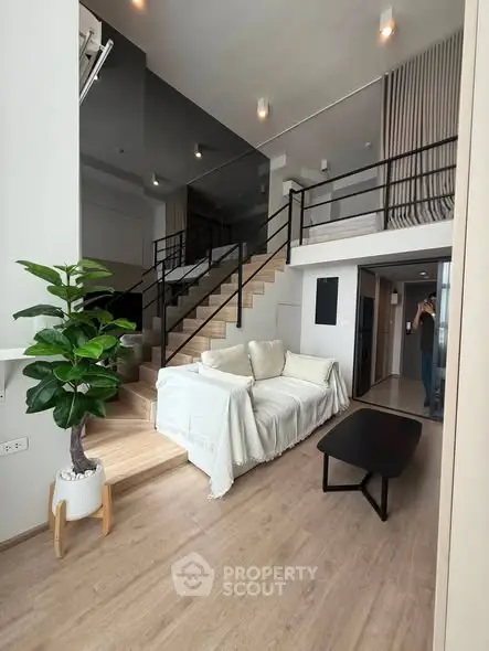 Modern duplex living room with stylish staircase and cozy seating area