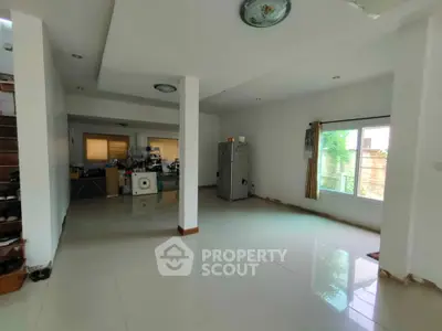 Spacious open-plan living area with large window and modern appliances