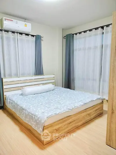 Cozy bedroom with modern wooden bed frame and soft lighting, perfect for relaxation.