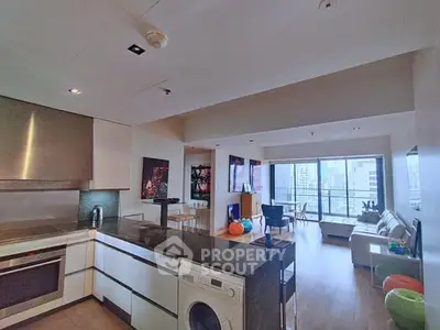 Spacious modern living room with open kitchen and city view balcony.