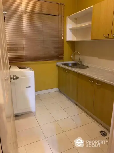 Cozy kitchen with wooden cabinets and washing machine in compact layout