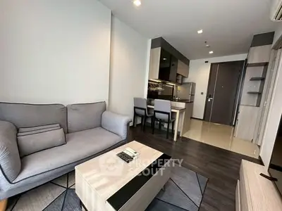 Modern living room with cozy sofa and open kitchen layout in stylish apartment.