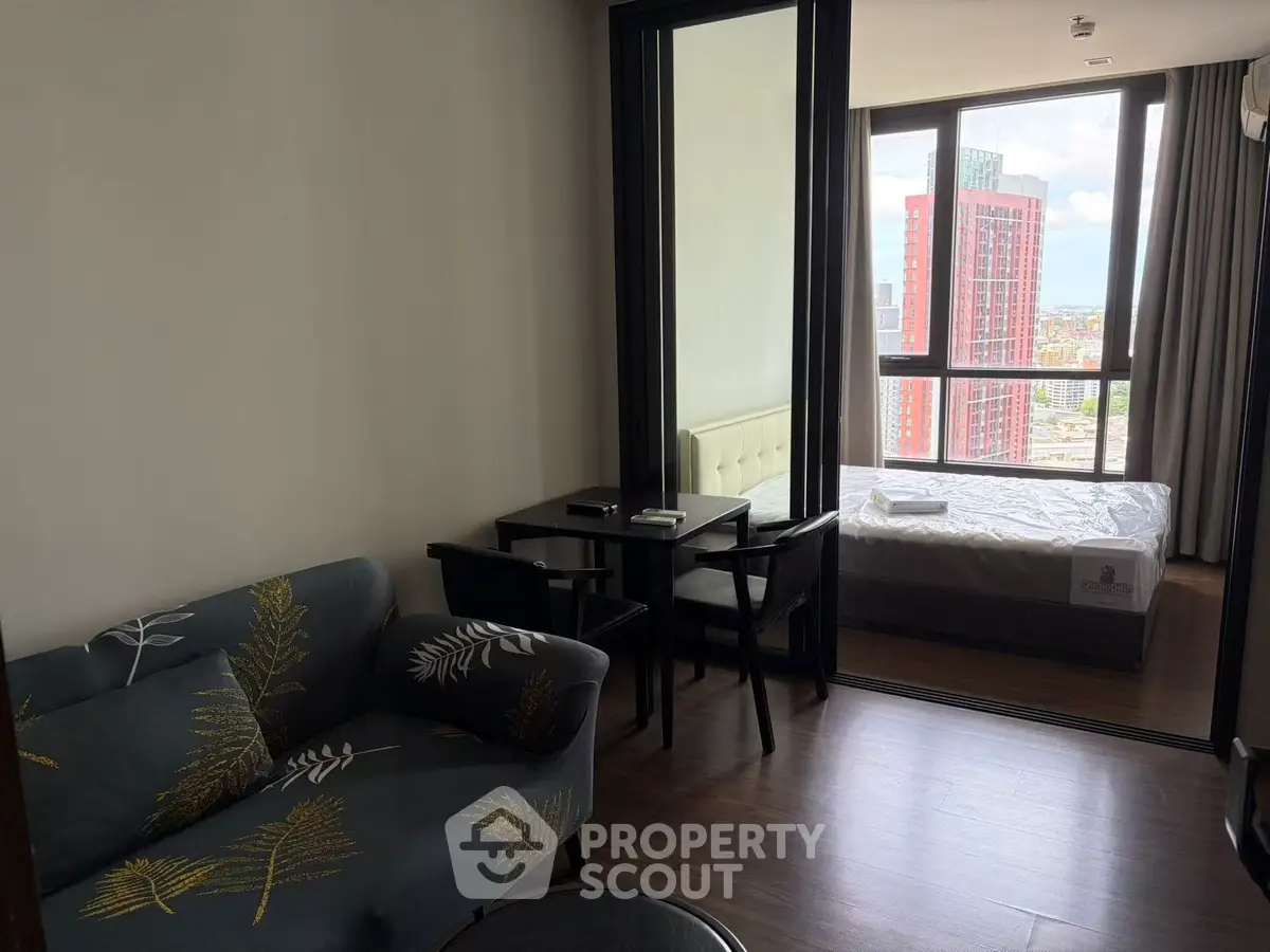 Modern apartment with cozy living room and bedroom, featuring large windows and stylish furniture.