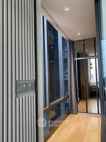 Modern hallway with wooden flooring and mirrored closet doors in a luxury apartment.