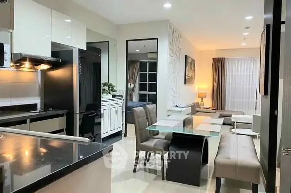 Modern open-layout kitchen and living room with sleek design and elegant furnishings.