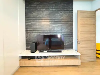 Modern living room with sleek TV setup and stylish wood accents