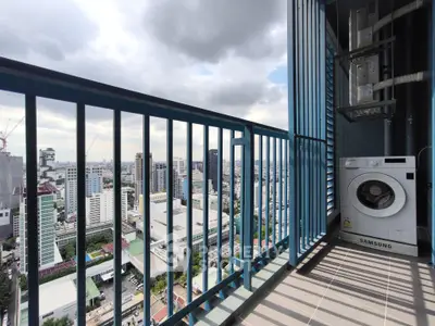 High-rise balcony with city view and washing machine, perfect urban living.