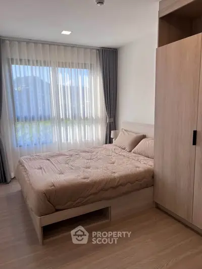 Modern bedroom with large window and elegant curtains in a stylish apartment.