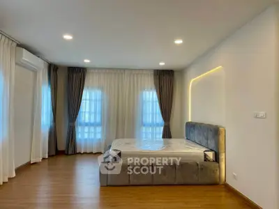 Spacious bedroom with modern design and large windows for natural light.