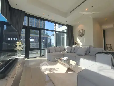 Luxurious modern living room with large windows and elegant decor in a high-rise apartment.