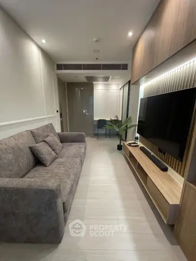 Modern living room with sleek design, large TV, and comfortable sofa in stylish apartment.