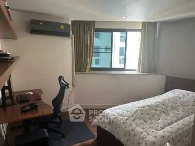 Cozy bedroom with study area, featuring a window view and modern furnishings.