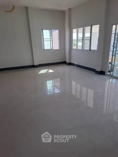 Spacious and bright empty room with large windows and glossy tiled floor, perfect for customization.