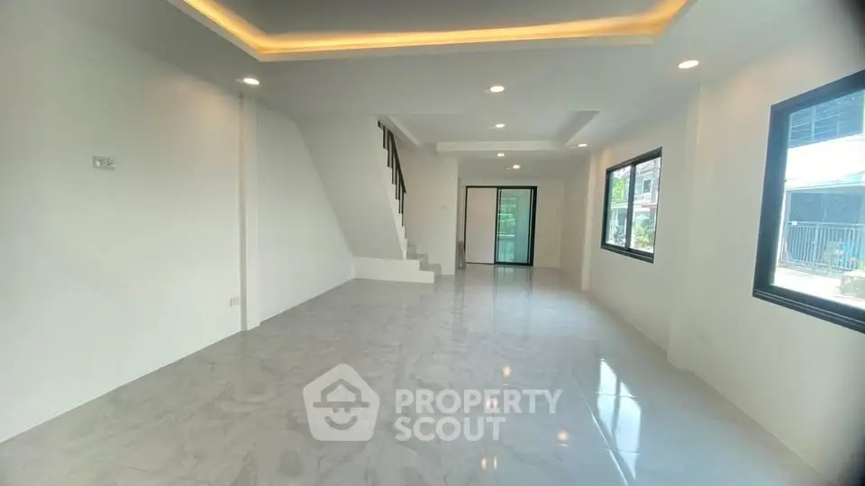 Spacious modern living room with large windows and sleek tile flooring