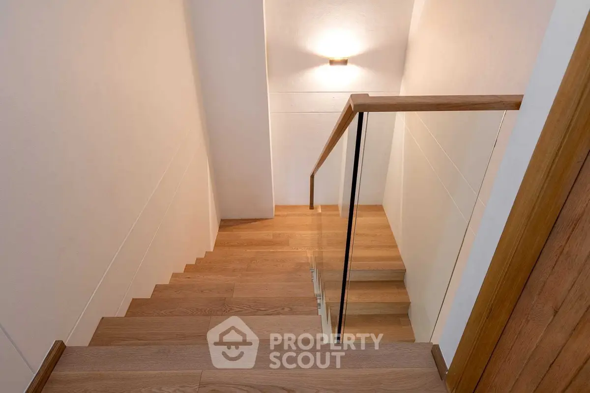 Elegant wooden staircase with modern glass railing in a contemporary home