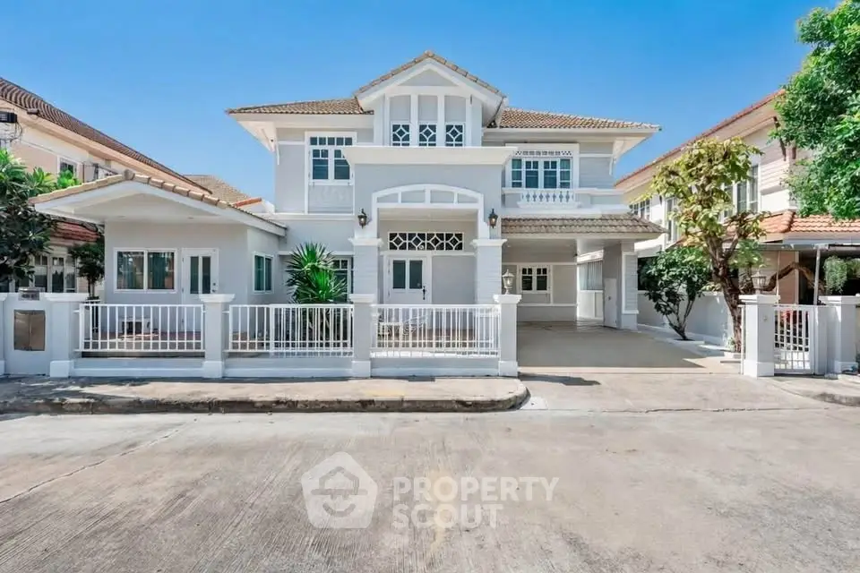 Stunning two-story white house with elegant facade and spacious driveway in a serene neighborhood.