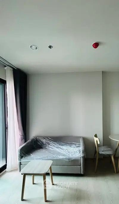 Modern living room with minimalist furniture and large window for natural light.