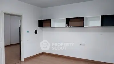 Spacious empty room with modern wall cabinets and wooden flooring